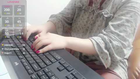 Media: Video of a person with fair skin, wearing a floral shirt, typing on a black keyboard. The background includes a fitness tracker display showing heart rate, steps, and calories.