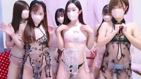 Media: Video of five East Asian women in see-through lingerie, featuring intricate black lace patterns, wearing face masks, in a bedroom with pink curtains.