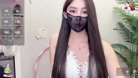 Media: Video of an Asian woman with long black hair, wearing a black mask and white lace top, standing indoors with a live stream overlay showing health stats.