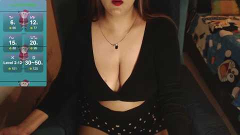 Media: Video of a woman with fair skin, wearing a plunging black top, black shorts with white polka dots, and red lipstick, sitting in a bedroom with a colorful, cartoon-themed bedspread.