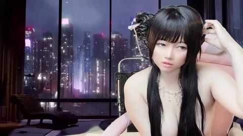 Media: Video of an Asian woman with long black hair in a bun, wearing a white top, seated in a modern room with a cityscape view through large windows.