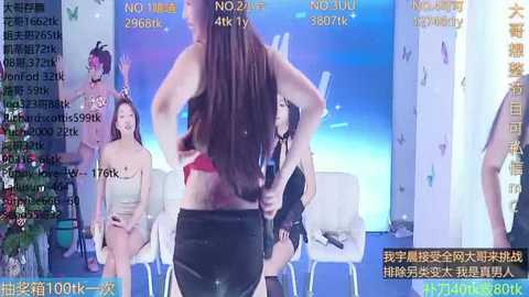 Media: A video captures a live broadcast of a female model wearing a red bra and black shorts, interacting with three women in similar attire on a stage. The background features a butterfly theme.