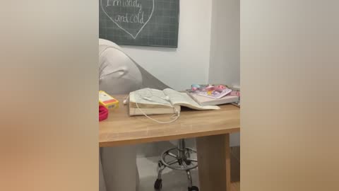 Media: A video of a cozy office corner featuring a wooden desk with an open book, a phone, and a chalkboard wall with the phrase \"I'm sorry\" and a heart.