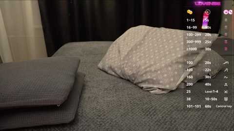 A video shows a gray pillow with white polka dots on a textured gray bedspread, overlaid with a digital display showing heart rate, oxygen level, and other health metrics.