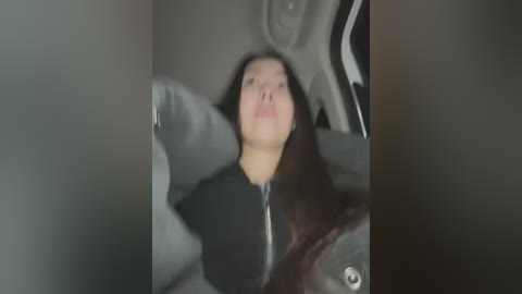 Media: A blurry video shows a young woman with long dark hair, wearing a black jacket, slumped in the driver's seat of a car, eyes closed. The interior is dimly lit.