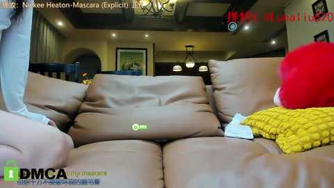 Media: Video of a cozy living room with a brown leather couch, a yellow throw blanket, and a red hat, featuring a TV screen displaying a health report.