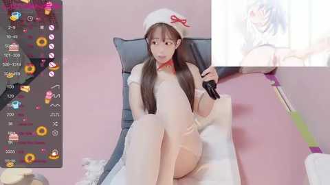 Media: Video of a young Asian woman in a white nurse outfit, sitting on a bed, holding a syringe, with a pink background and a video game interface on the left.