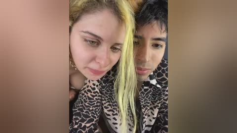 Media: Video of two young people with fair skin, one with blonde hair, the other with dyed yellow hair, wearing leopard-print shirts, standing close together.