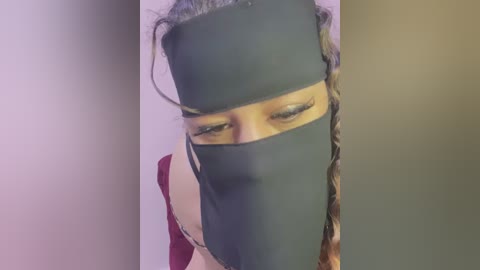 Media: A video of a person with light skin and short brown hair, wearing a dark mask that covers the nose and mouth, set against a plain white background.