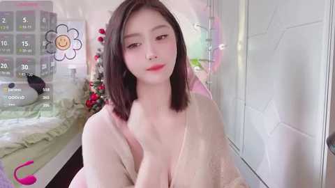 Media: Video of an East Asian woman with fair skin, straight black hair, and red lipstick, wearing a beige lace top, in a bright, modern room with a digital clock and a bed.