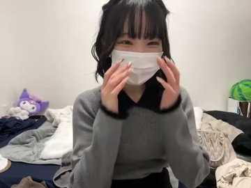 Media: A video of an East Asian woman with black hair, wearing a gray sweater and white mask, hands over her face. Background shows a messy room with stuffed animals, clothes, and a green trash can.