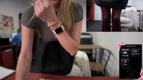 Media: Video of a blonde woman wearing a green ribbed top and black skirt, using a smartwatch, in a modern office with a chair and table.