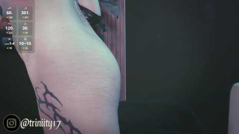 Media: A video of a person with fair skin and a tribal tattoo on the left shoulder, taken from a side angle. The background is dark and indistinct.