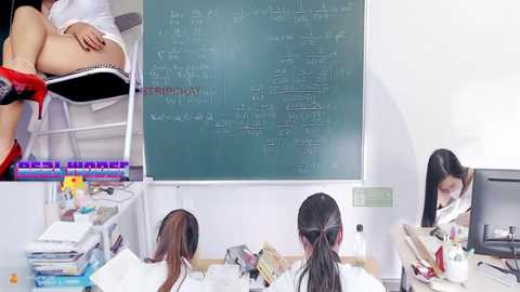 Media: Video of three Asian women in a classroom with a chalkboard, desks, books, and one woman in a red dress.