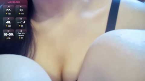 Media: Video of a woman with fair skin and large breasts, wearing a black bra, partially covered by her hands. The background is blurred, featuring a digital overlay with health stats and a \"LOUVERE\" logo.