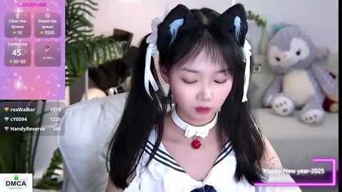 Media: A video of an Asian woman with long black hair, wearing cat ear headbands and a white sailor outfit with a red bow. Background features a plush teddy bear. Live stream overlay shows viewers' chat and statistics.