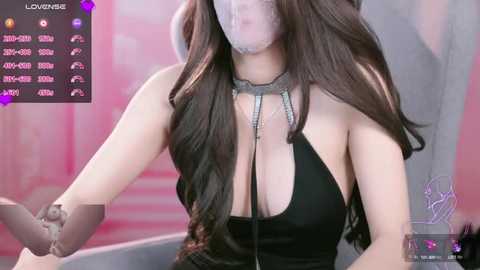 A video of a woman with long brown hair, wearing a black halter top, a choker, and a see-through face mask. Background features pink and purple hues with streaming text and icons.