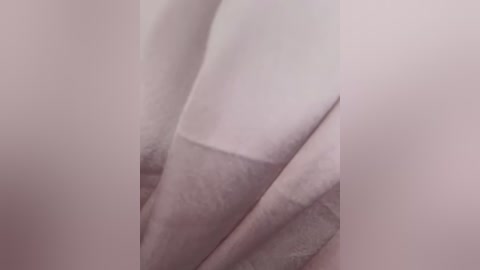 Media: A close-up video of two fingers with neatly trimmed, light-colored fingernails, partially covered by soft, white fabric, creating a gentle, intimate, and serene atmosphere. The image is soft-focused and emphasizes texture and softness.