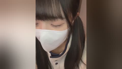 Media: Video of an East Asian woman with long black hair in pigtails, wearing a white face mask, and a white and navy blue school uniform, eyes closed, looking downward.