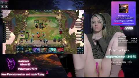 Media: A screenshot of a live stream featuring a young woman with long blonde hair, wearing a dark hoodie, playing League of Legends. Her legs are spread, exposing her pink panties.