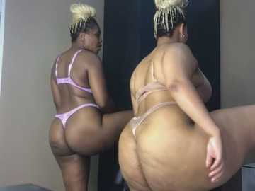 Media: Video of a curvy Black woman with large breasts and ample hips in a pink lace thong and bra, showing her toned backside, wearing blonde dreadlocks.