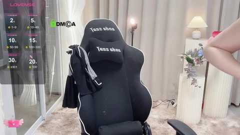 Media: Video of a gamer in a black gaming chair with \"Trezon 8\" text, surrounded by a virtual screen showing stats, in a modern, cozy room with beige curtains and a lamp.