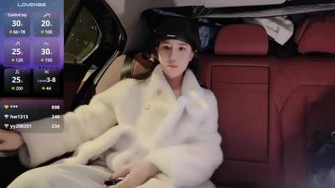 Media: A video of a young woman in a white fur coat, seated in the backseat of a luxury car, with a weather app display showing 25\u00b0C.