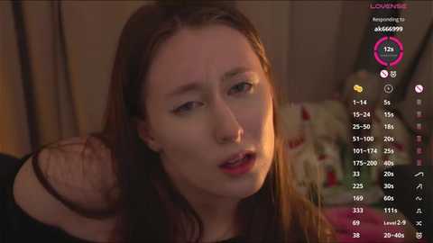 Video of a distraught young woman with light skin, long brown hair, and reddened eyes, holding a man's bloody, mangled arm in a dimly lit room.