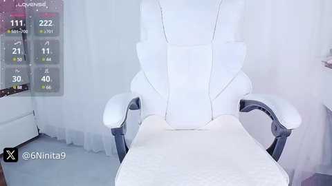 Media: Video of a white gaming chair with a cushioned backrest, positioned in front of a white background with a digital health screen displaying stats.