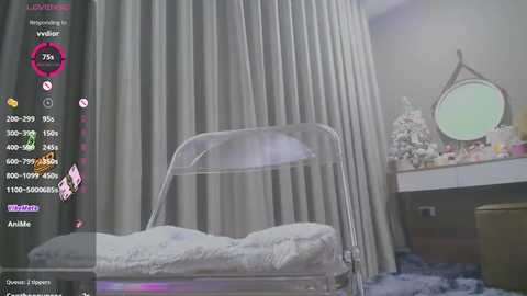 Media: Video of a minimalist bedroom with a clear plastic chair, white curtains, a vanity table, and a round mirror, set in a modern, light-toned room.