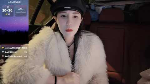 Media: A video of a young East Asian woman with fair skin, straight black hair, and full lips, wearing a black hat and a white fur coat, sitting in a car at night, with a digital display showing her social media stats.