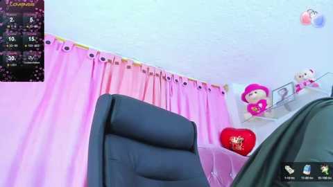 Media: Video of a pink-themed room with pastel walls, pink curtains, and plush toys, including a Hello Kitty figure. A black leather recliner chair is positioned in the foreground.