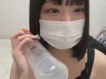 Media: Video of an Asian woman with straight black hair and a white surgical mask, holding a clear bottle of hand sanitizer, wearing a black lace-trimmed top.