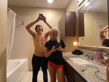 Media: Video of two shirtless men and a woman in a bathroom; one man holds a phone above his head, another takes a selfie, and the woman looks at her phone.