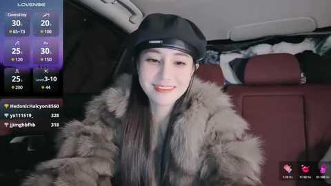 Media: A video of a smiling, fair-skinned woman with long, straight hair in a fur coat, sitting in a car.