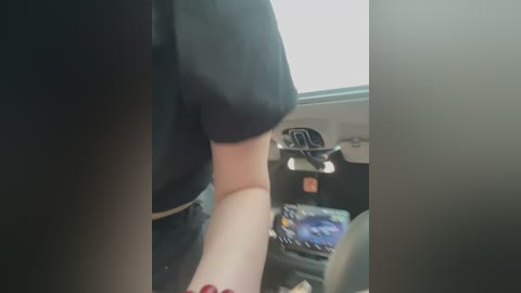 Media: A blurry video shows a person in a black shirt, likely a police officer, seated in a car. The steering wheel and dashboard are visible, with a red light and a map on the seat.