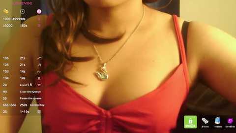 Media: A close-up video of a woman with light skin and long brown hair, wearing a red spaghetti-strap top, and a silver necklace with a heart pendant. The background shows a social media app interface.