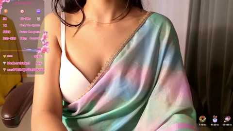 Media: A video shows a woman in a pastel tie-dye saree, white bra peeking out, dark hair, in a dimly-lit room, with social media icons in the corner.