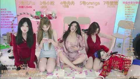 Media: Video of five Asian women, all with long hair, in various red and pink outfits, kneeling on a pink floor with scattered rose petals, in a brightly lit, pink-themed room with Chinese text.