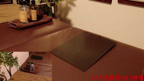 Media: Video of a corner of a kitchen with a wooden counter, a red and brown cloth, glass bottles, a plant, and a black stove. Japanese text in the bottom right.