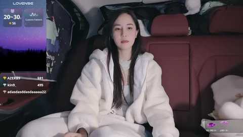 Media: A video of a young East Asian woman with long black hair, wearing a white robe, sitting in a car at night. The car's interior is dimly lit, showing a starry sky through the window.