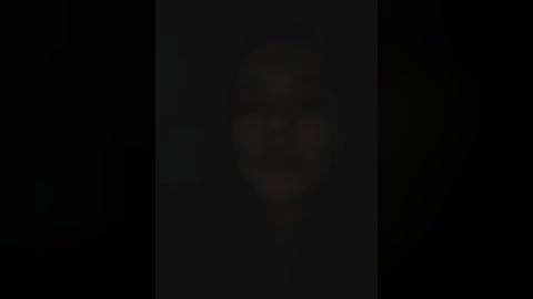 Media: A video showing a blurred, dark silhouette of a person against a black background. The subject's identity and features are indistinguishable due to the heavy darkness.