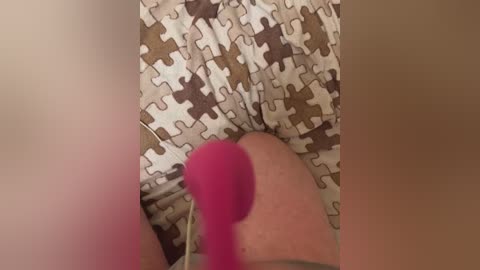 Media: Video of a person's legs, wearing patterned shorts, with a pink vibrator inserted into a vagina, visible through the shorts.