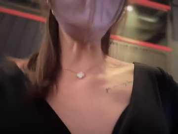 Media: A video of a woman wearing a black dress, with a visible tattoo on her right shoulder, in a dimly lit room.