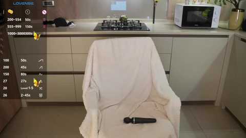 Media: A video of a modern kitchen with a beige chair draped in a white towel, a microwave, and a stove, overlaid with a virtual reality interface showing a woman in a black outfit.