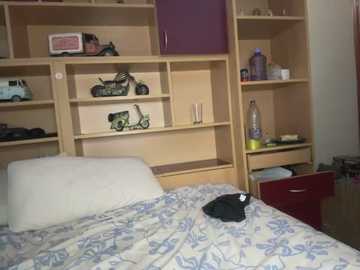 Media: Video of a tidy bedroom with a white bed, light wooden shelves holding various items, including a black motorcycle toy, purple cabinet, and a red drawer.