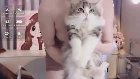 Media: Video of a nude woman cradling a large, fluffy gray and white cat in a bedroom with a pink poster of a cartoon character on the wall.