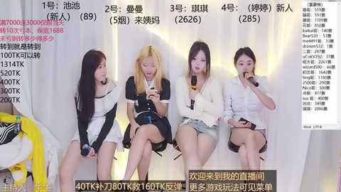 Media: Video of four young Asian women, two wearing black and white outfits, two in casual clothes, sitting on a couch, eating, background with Chinese text.