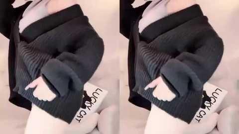 Media: A video of a person wearing a black cardigan and white underwear, with a white bag labeled \"LOVE\" in black text. The image is taken from a side angle, showcasing a close-up of the torso and lower body.