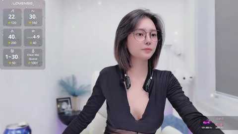 Media: A video of an Asian woman with straight black hair, wearing glasses, a black low-cut top, and headphones. She's in a minimalist, white room with a digital display showing health metrics.